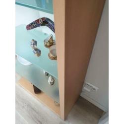 Boekenkast met glasplaten en witte achterwand.