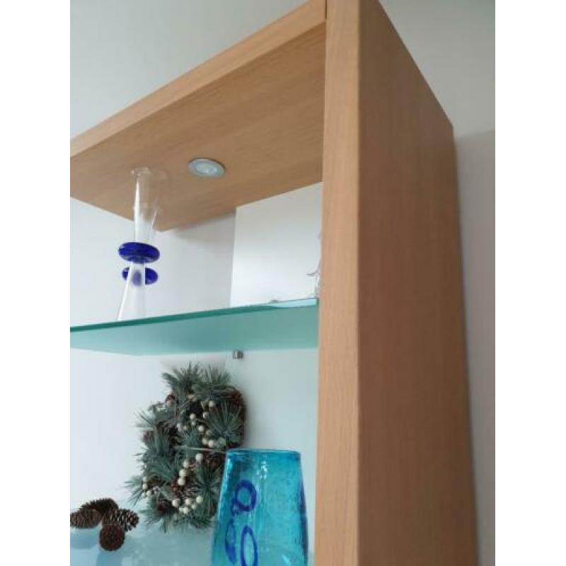Boekenkast met glasplaten en witte achterwand.