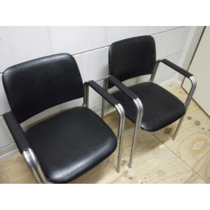 2 zwarte fauteuils met armleuningen en chroom onderstel