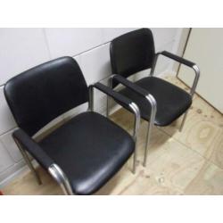 2 zwarte fauteuils met armleuningen en chroom onderstel