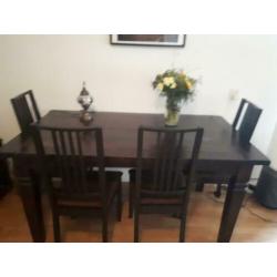 Tafel met donkerbruine stoelen stoffen zitting.