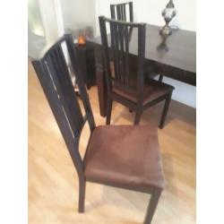Tafel met donkerbruine stoelen stoffen zitting.