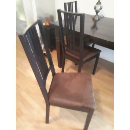 Tafel met donkerbruine stoelen stoffen zitting.