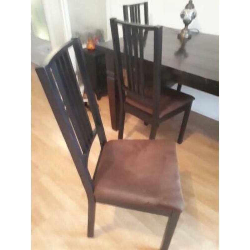 Tafel met donkerbruine stoelen stoffen zitting.