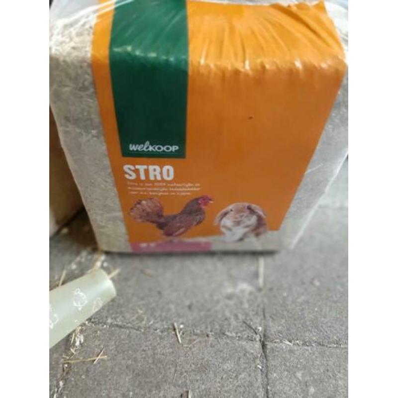kippen voer en drinkbakken hooi stro