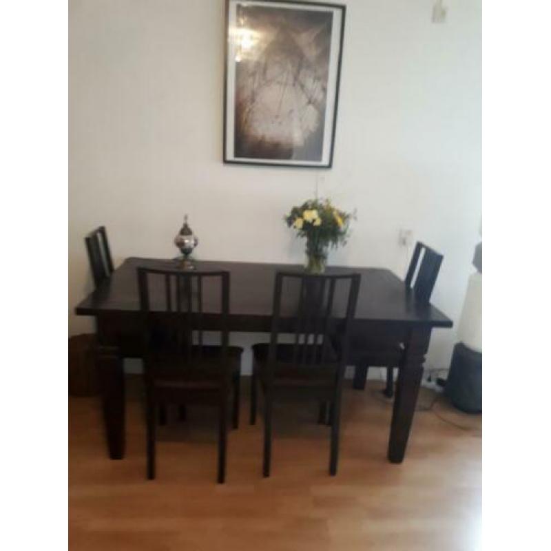 Tafel met donkerbruine stoelen stoffen zitting.