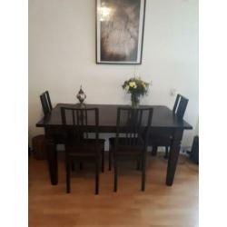 Tafel met donkerbruine stoelen stoffen zitting.